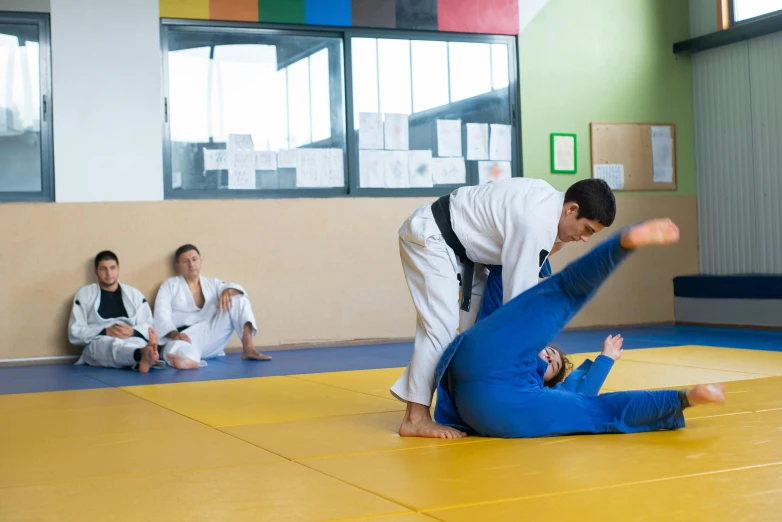 a group of people sitting on top of a yellow mat, white belt, melbourne, action sports, private school
