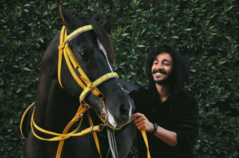 a man that is standing next to a horse, pexels contest winner, imaan hammam, black and yellow, raden saleh, very very happy