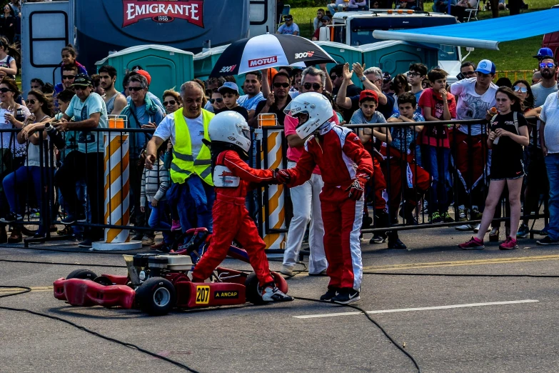 a group of people standing around a race car, a picture, pexels contest winner, les automatistes, crashcart, kids, low quality photo, thumbnail