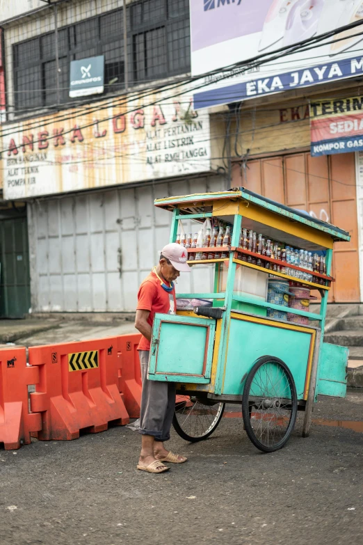 a man that is standing next to a cart, a picture, inspired by Willie Ito, trending on unsplash, sumatraism, city streetscape, breakfast, b - roll, square