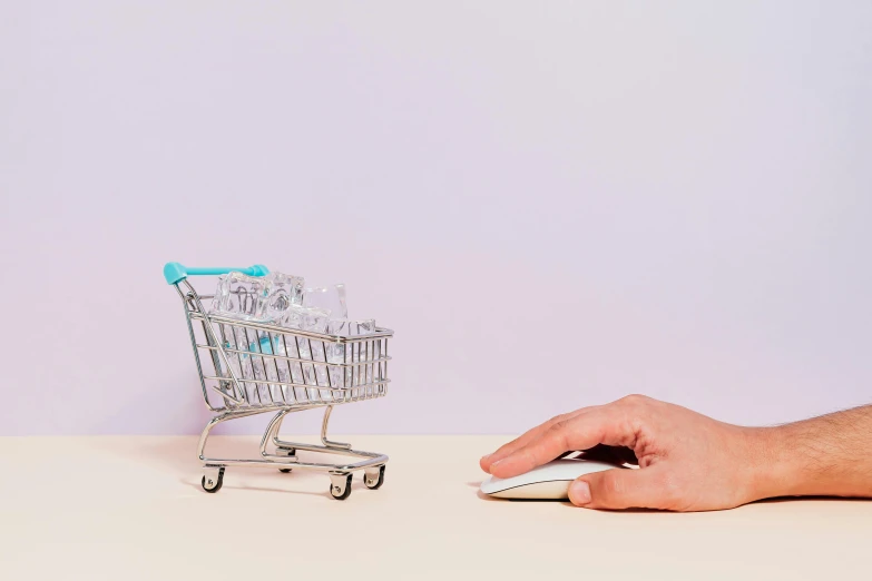 a hand holding a mouse next to a miniature shopping cart, a digital rendering, pexels, arper's bazaar, hands on counter, max hay, empty background