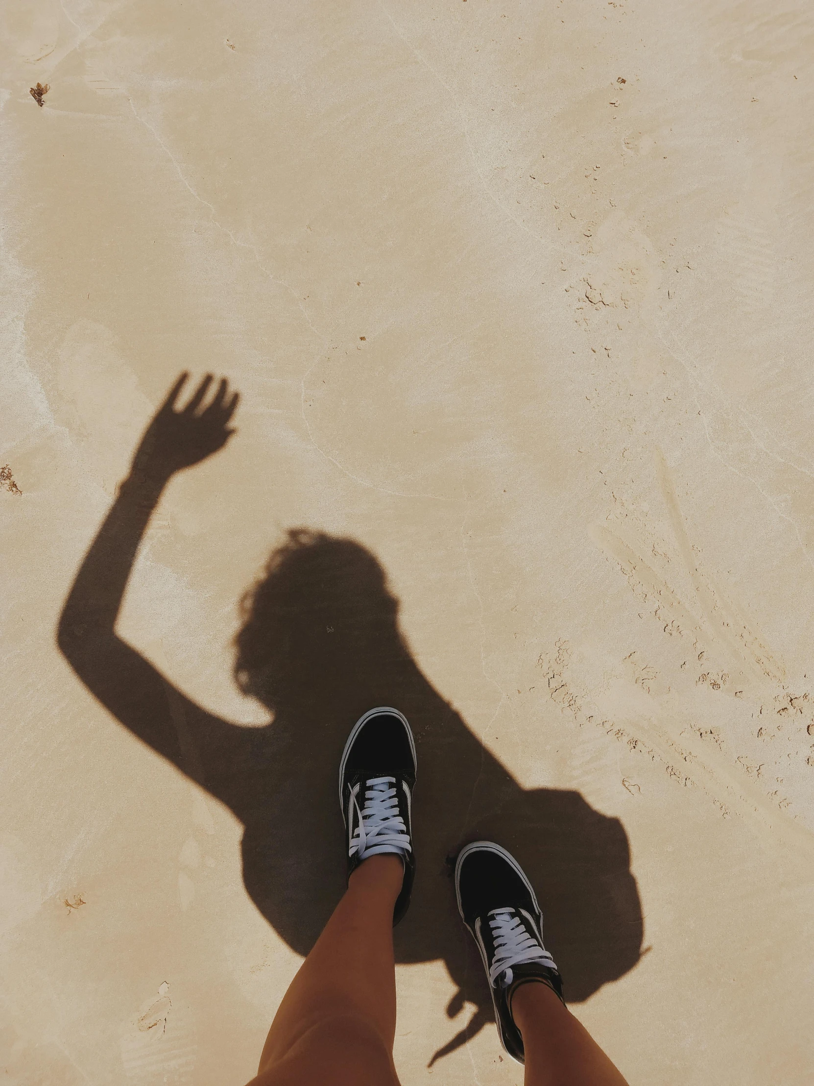 a person standing on top of a sandy beach, by Robbie Trevino, pexels contest winner, realism, perfect shadow, high soles, trending on vsco, her face is in shadow