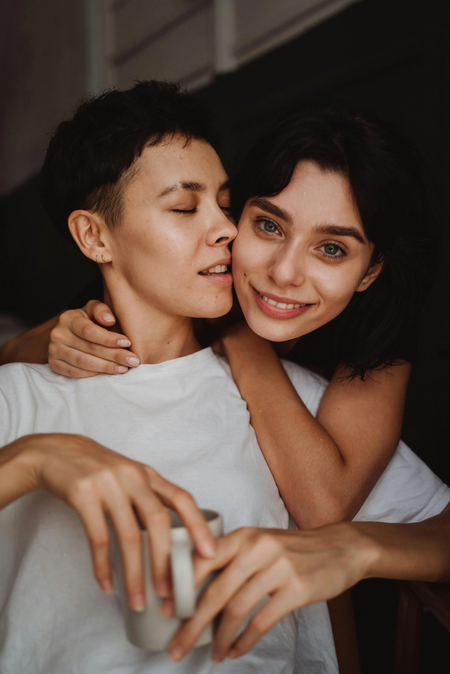 a couple of people that are hugging each other, trending on pexels, antipodeans, non binary model, someone sits in bed, mai anh tran, lesbian