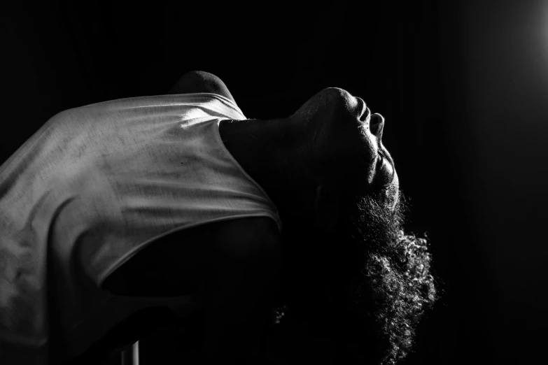 a black and white photo of a man with long hair, inspired by Carrie Mae Weems, pexels contest winner, art photography, she is laying on her back, dramatic backlit lighting, neck up, african american woman