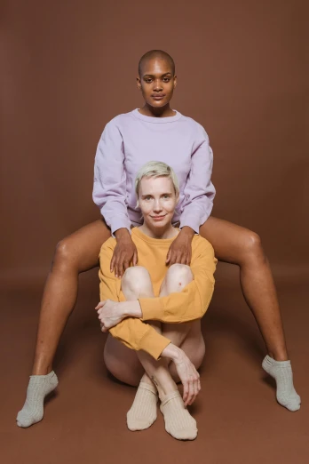 two women sitting on top of each other, inspired by Vanessa Beecroft, trending on pexels, renaissance, wearing a sweater, nonbinary model, 4 legs, ochre