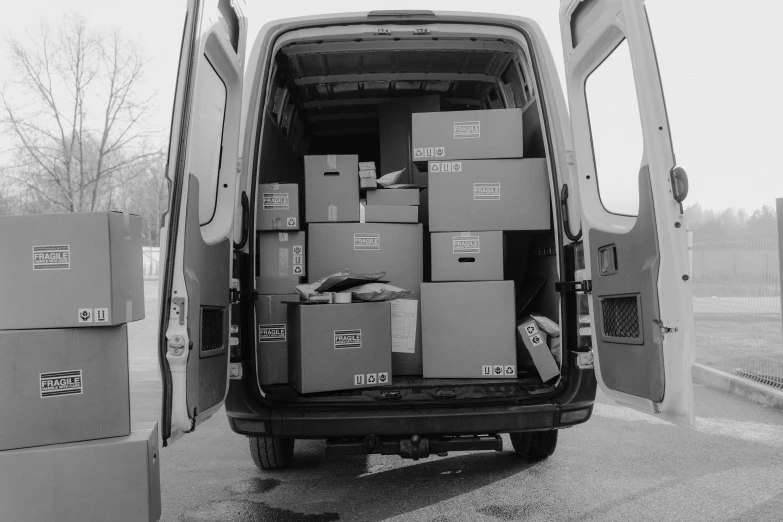 a black and white photo of a van loaded with boxes, by Kristian Zahrtmann, 15081959 21121991 01012000 4k, elena masci, server, spare parts