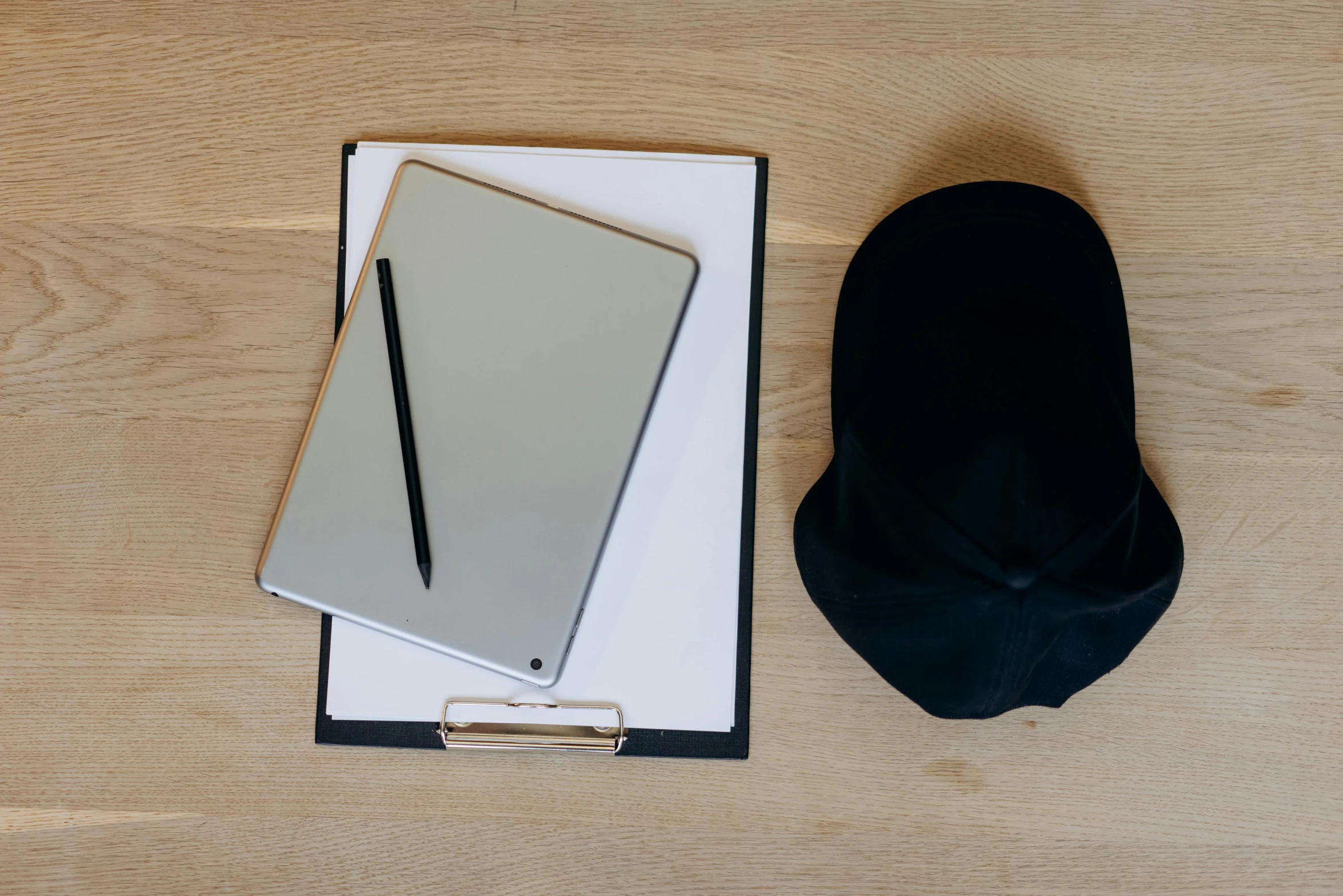 a notepad sitting on top of a clipboard next to a hat, unsplash, computer art, 9 9 designs, black beret, whiteboards, looking from shoulder