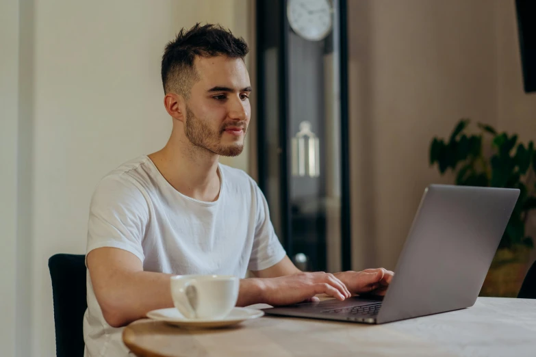 a man sitting at a table using a laptop computer, trending on pexels, around 20 yo, avatar image, aussie baristas, professional image