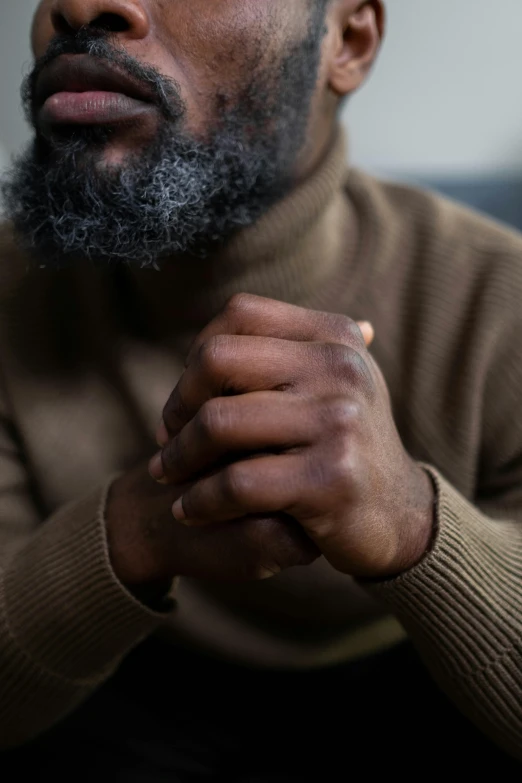 a man with a beard sitting on a couch, by Brad Holland, trending on pexels, prayer hands, black tendrils, gray men, 15081959 21121991 01012000 4k