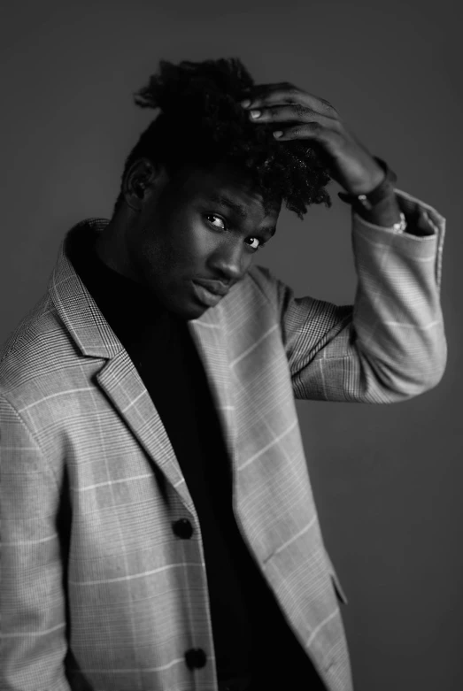 a black and white photo of a man in a suit, an album cover, pexels contest winner, realism, black teenage boy, casual pose, ( ( dark skin ) ), alphonse fly