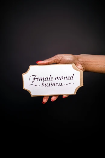 a woman holding a sign that says female owned business, an album cover, profile image, photographed for reuters, feminine curves, high quality upload