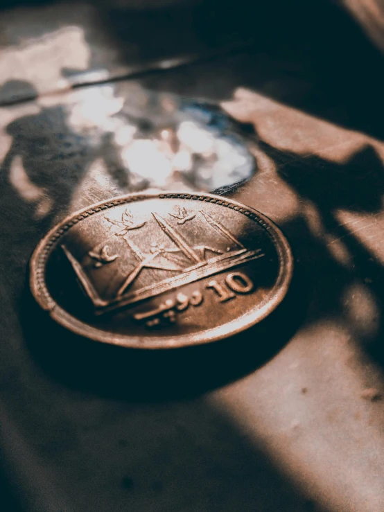 a close up of a coin on a table, pexels contest winner, israel, vintage vibe, ( ( theatrical ) ), front lit