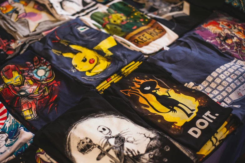 a pile of t - shirts sitting on top of a table, a cartoon, pexels, pokemon inspired, gothic clothing, mid shot photo, wearing shorts and t shirt