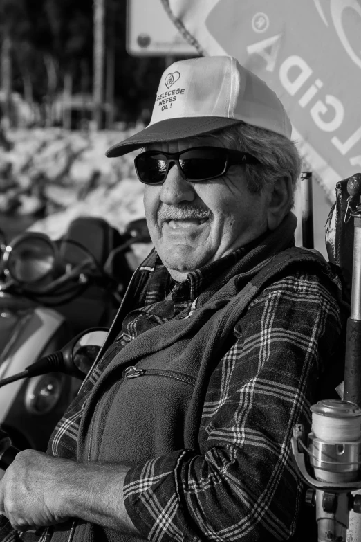 a black and white photo of a man sitting on a motorcycle, a black and white photo, by Dave Melvin, he is about 7 0 years old, portrait of an adventurer, at circuit de spa francorchamps, portrait of a rugged ranger