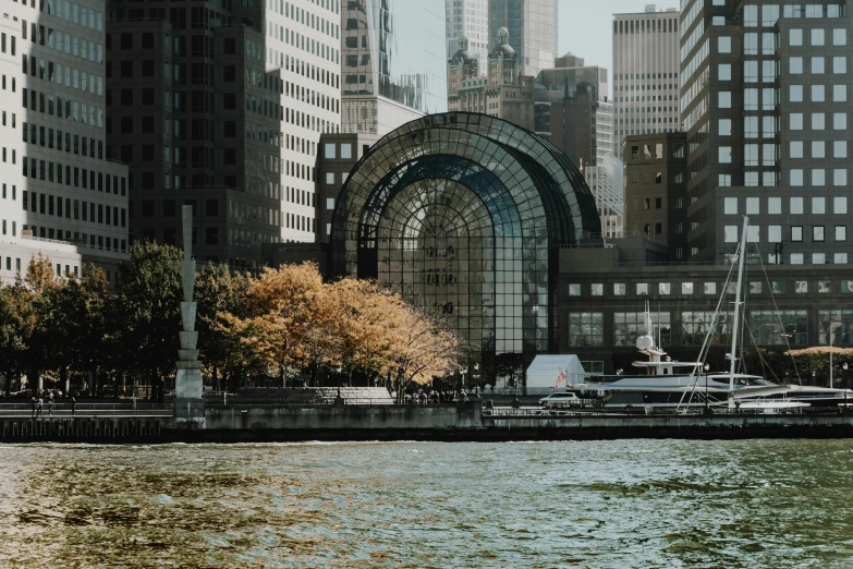 a large body of water surrounded by tall buildings, a photo, inspired by Peter Benjamin Graham, pexels contest winner, visual art, glass dome, muted fall colors, calatrava, 2000s photo