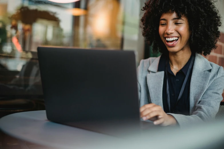 a woman sitting at a table using a laptop computer, pexels contest winner, both laughing, close up to the screen, young business woman, thumbnail