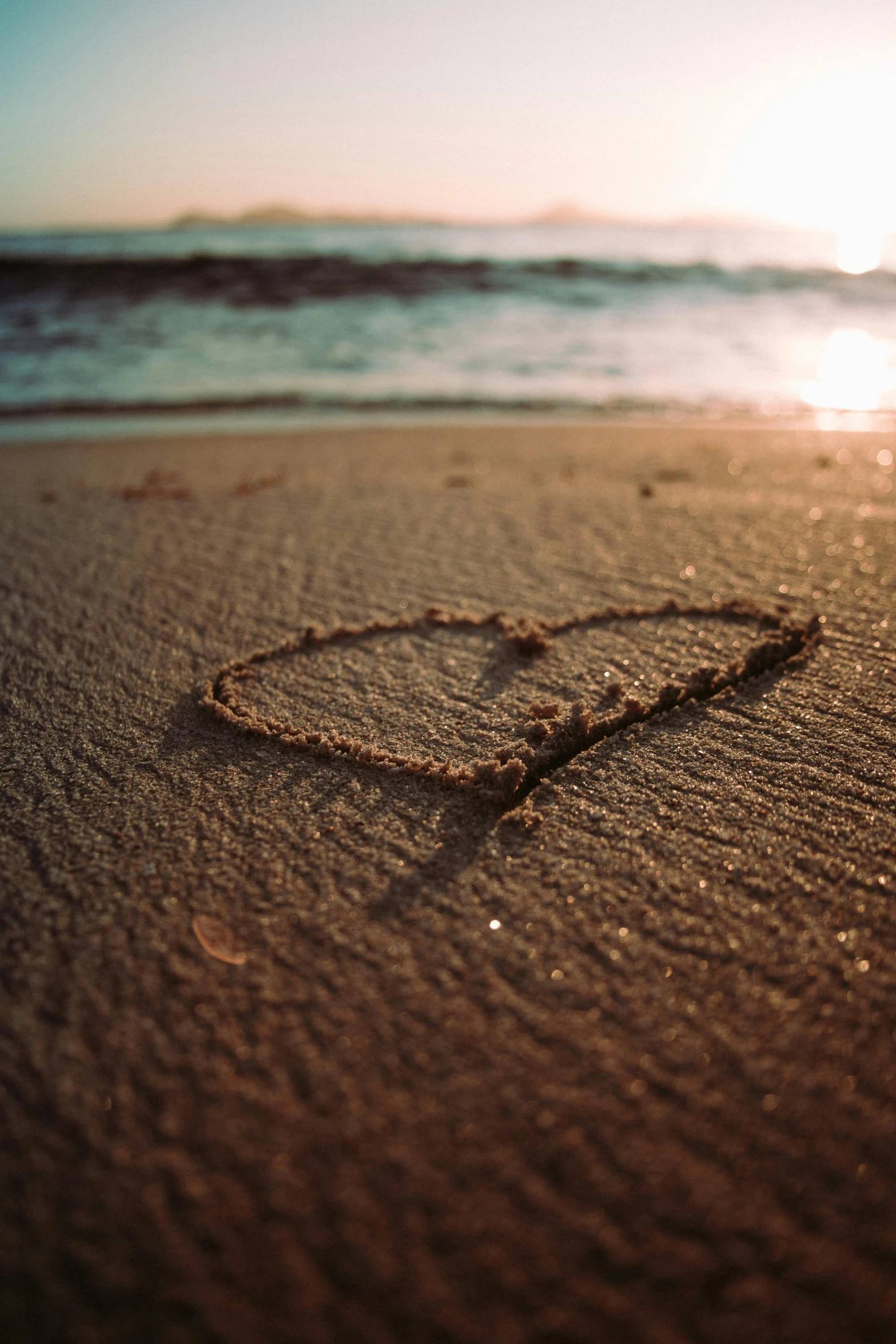 a heart drawn in the sand on a beach, an album cover, unsplash, paul barson, vacation, evening sunlight, ox