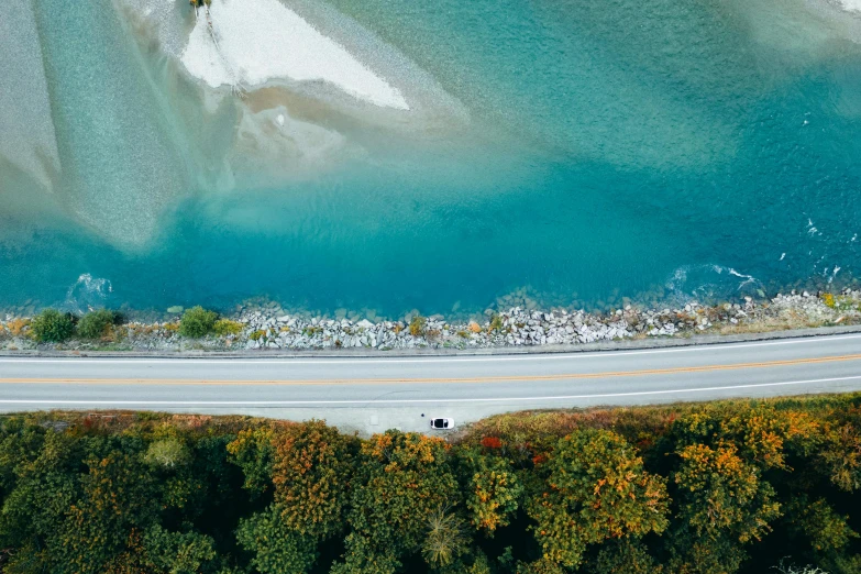 an aerial view of a road next to a body of water, pexels contest winner, teal landscape, vehicle, thumbnail, switzerland