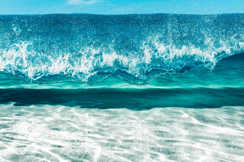 a close up of a wave in the ocean, an album cover, blue sand, vibrant blue, beaches, teal