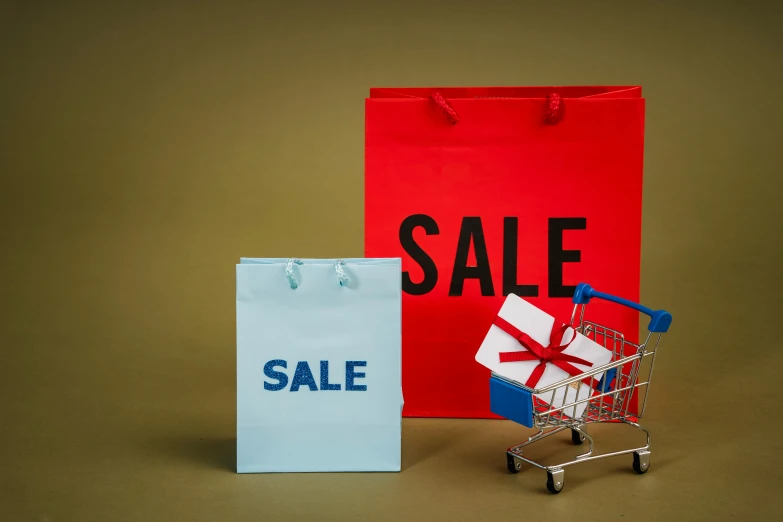a shopping cart sitting next to a shopping bag with a sale sign on it, pexels contest winner, hyperrealism, square, holiday, emma bridgewater and paperchase, red brown and blue color scheme