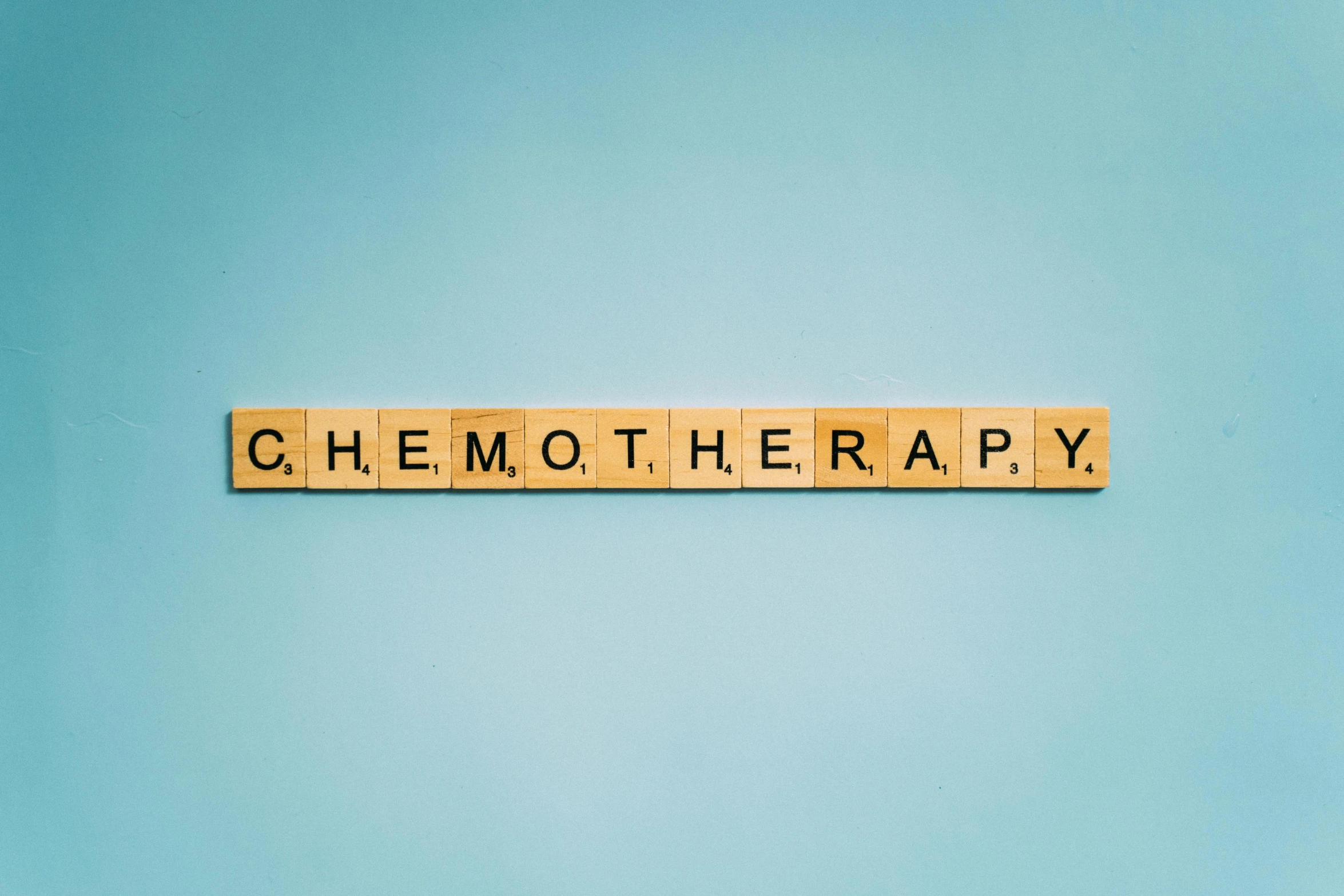 the word chemo therapy spelled in scrabbles on a blue background, colour corrected, of walter white, ecommerce photograph, honey
