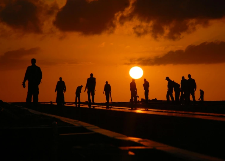 a group of people standing on top of a pier at sunset, by Jan Tengnagel, pexels contest winner, on aircraft carrier, workers, bali, people on the ground