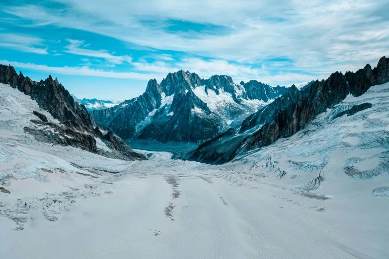 a snow covered mountain range with tracks in the snow, by Pierre Mion, pexels contest winner, glacier coloring, chamonix, vast expansive landscape, ground covered with snow