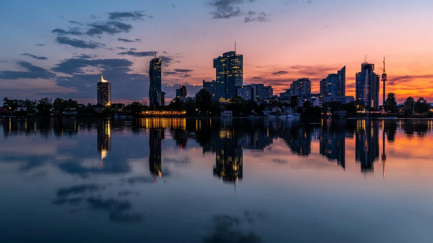 a large body of water with a city in the background, by Niko Henrichon, pexels contest winner, dawn and dusk, lake reflection, ukraine. photography, fine art print