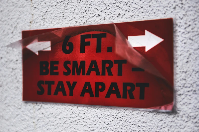 a red sign sitting on the side of a building, a poster, by Matt Stewart, pexels, street art, location in a apartment, smart, six sided, photograph credit: ap