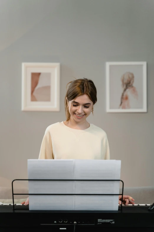 a woman sitting at a desk in front of a laptop computer, a picture, pexels contest winner, academic art, standing on top of a piano, smiling sweetly, sheet music, slightly minimal