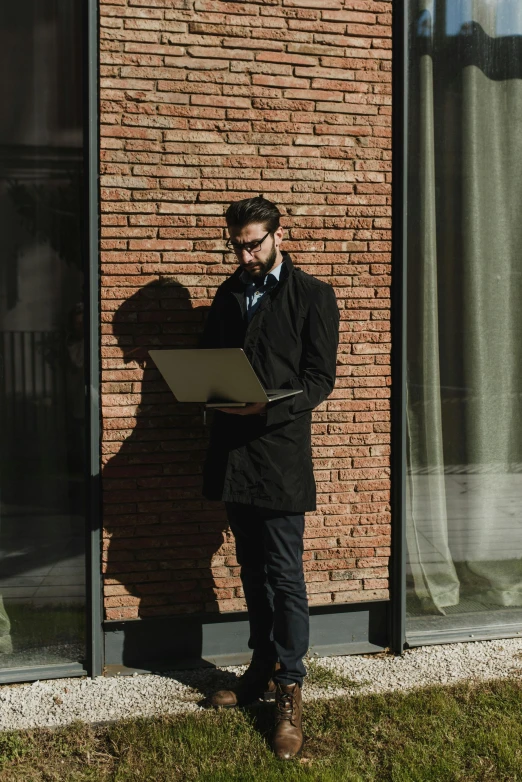 a man standing in front of a building with a laptop, profile image, alessio albi, reading, casually dressed