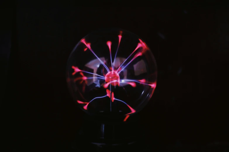 a plasma light bulb sitting on top of a table, unsplash, nuclear art, red and blue black light, spherical, pink lightning, frontal shot