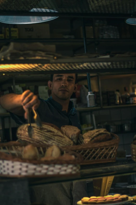 a man that is standing in front of a counter, by Alejandro Obregón, les nabis, sliced bread in slots, mohamed chahin style, low lighting, working hard