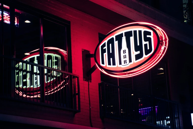 a neon sign hanging from the side of a building, fat belly, pathos, nighttime foreground, tafy