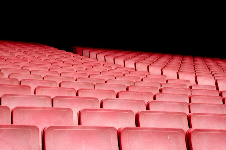 a group of red seats sitting next to each other, an album cover, inspired by Andreas Gursky, pexels, plasticien, sportspalast amphitheatre, movie lights, youtube thumbnail, [ theatrical ]