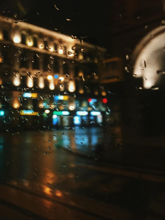 a view of a city at night through a rainy window, unsplash contest winner, hyperrealism, street of moscow, low quality photo, trending on vsco, bus stop on a rainy day