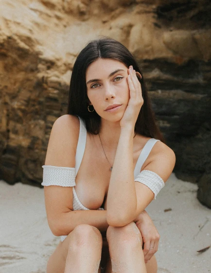 a woman sitting on top of a sandy beach, an album cover, by Adam Dario Keel, madison beer girl portrait, close up bust shot, with white skin, nonbinary model