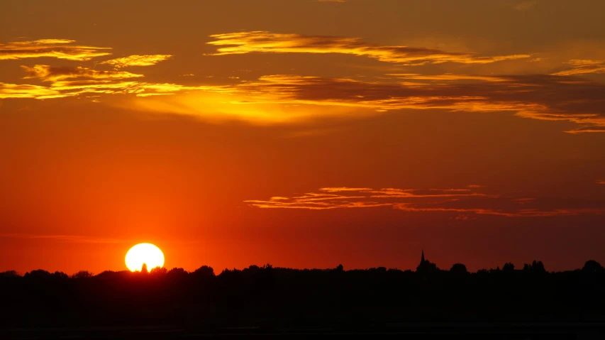 the sun is setting over the trees in the distance, by Jan Tengnagel, pexels contest winner, big red sun, skyline, heat waves, slide show