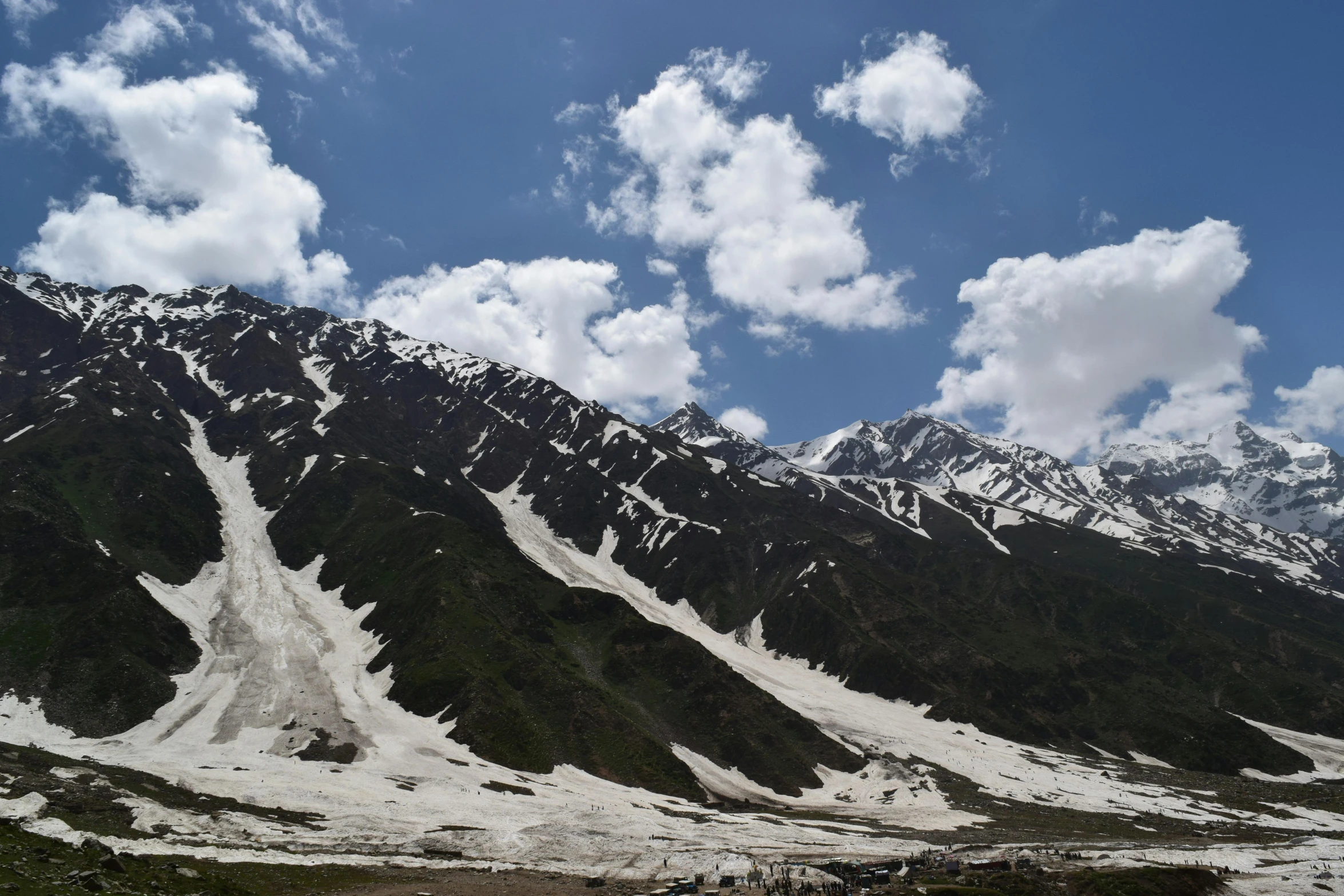 a group of people standing on top of a snow covered mountain, by Muggur, pexels contest winner, hurufiyya, landslides, summer sky, india, thumbnail