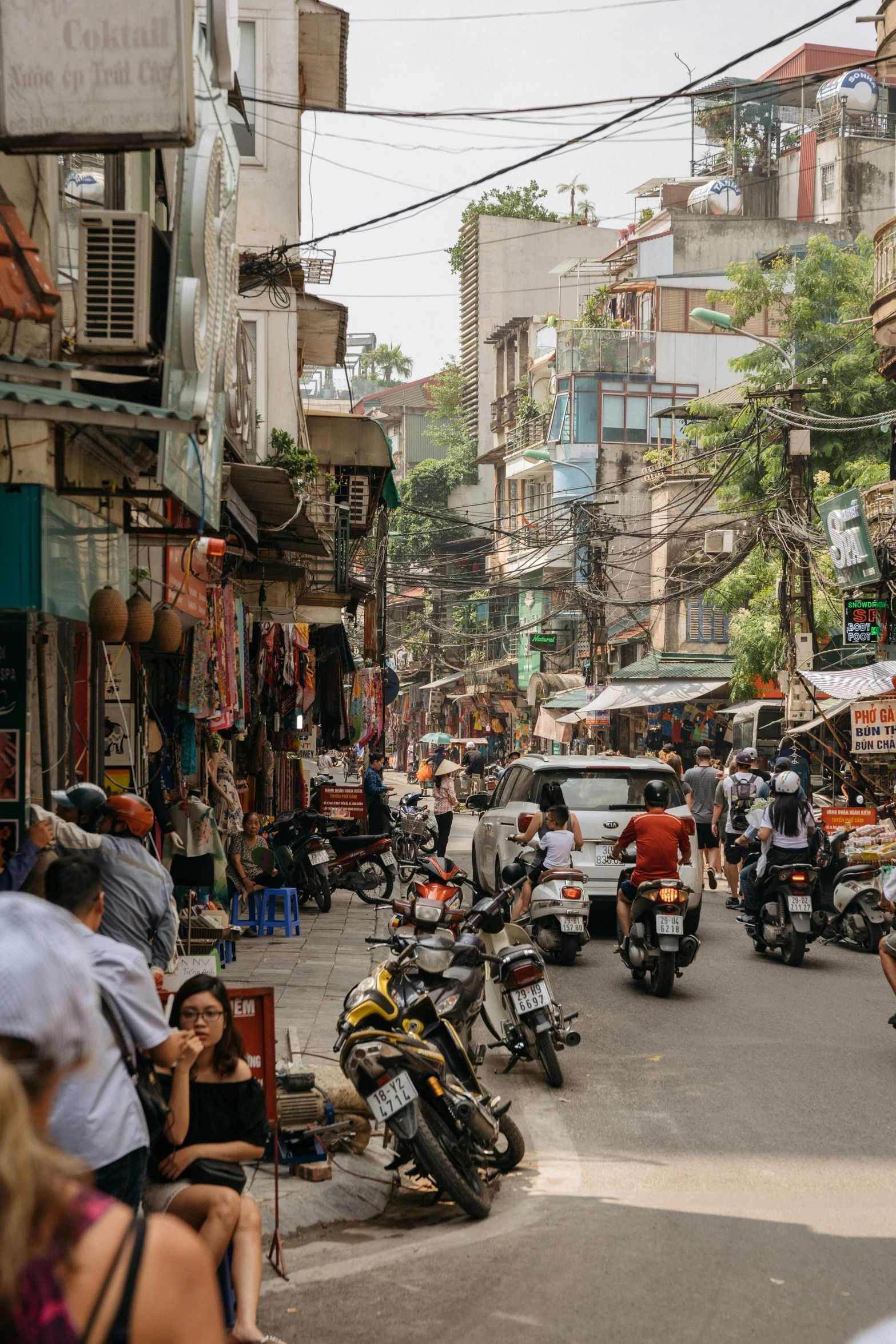 a group of people riding motorcycles down a street, inspired by Steve McCurry, trending on unsplash, old asian village, busy cityscape, shady alleys, panoramic shot