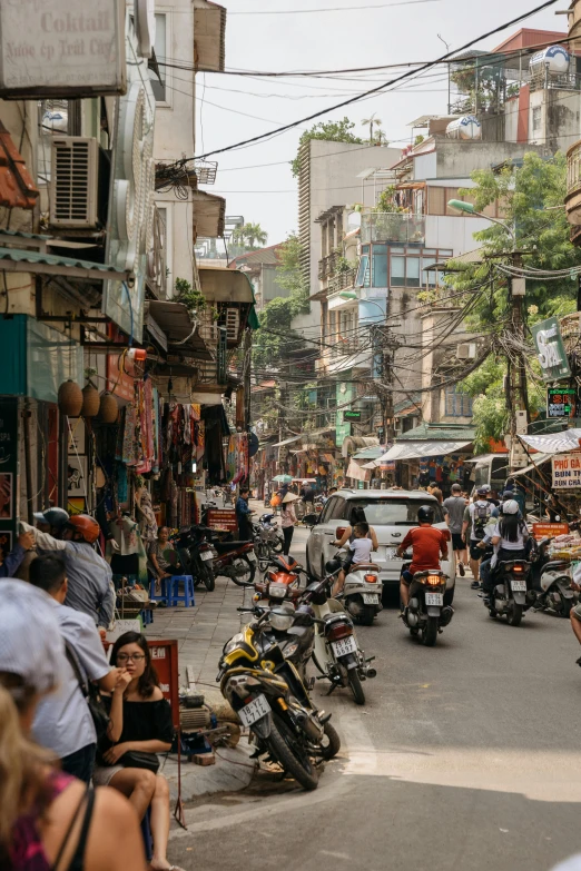 a group of people riding motorcycles down a street, inspired by Steve McCurry, trending on unsplash, old asian village, busy cityscape, shady alleys, panoramic shot