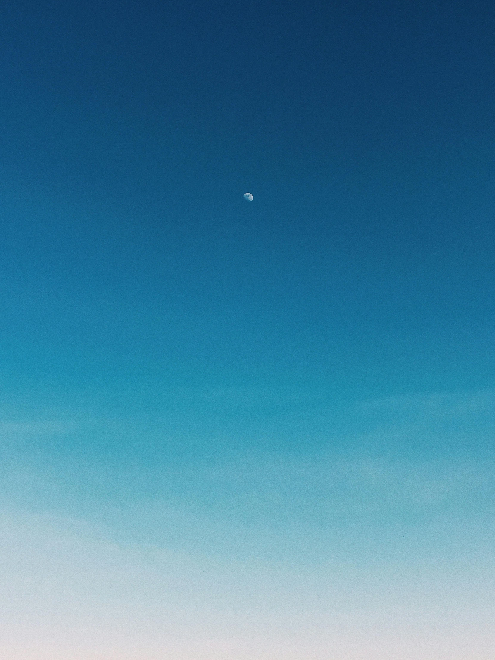 a plane that is flying in the sky, a minimalist painting, by Niko Henrichon, unsplash, postminimalism, the moon cast on the man, rinko kawauchi, clean blue sky, iphone wallpaper