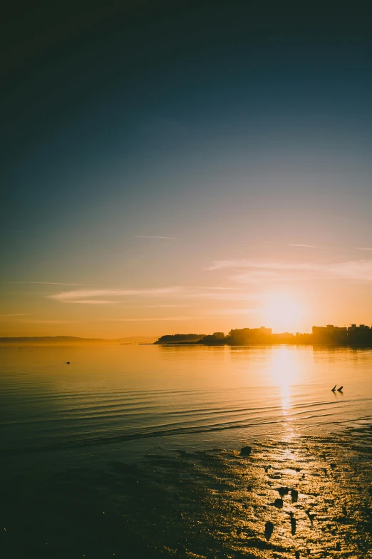 the sun is setting over a body of water, unsplash, wellington, wide angle”, yellow, instagram photo