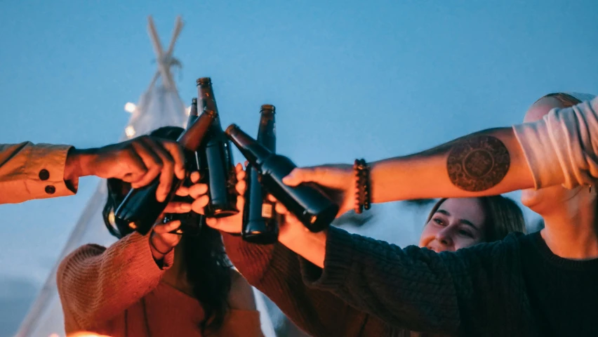 a group of people holding beer bottles in their hands, pexels contest winner, happening, earthship, avatar image, rooftop party, inuit heritage