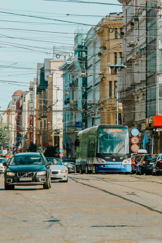 a street filled with lots of traffic next to tall buildings, by Adam Marczyński, pexels contest winner, rostov city, trams ) ) ), square, bright summer day