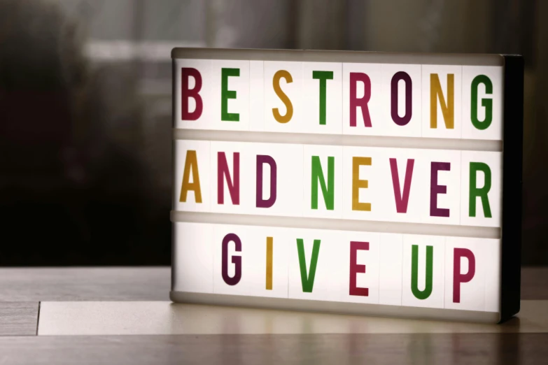 a sign that says be strong and never give up, pexels, light box, bright:, bust, dr dre