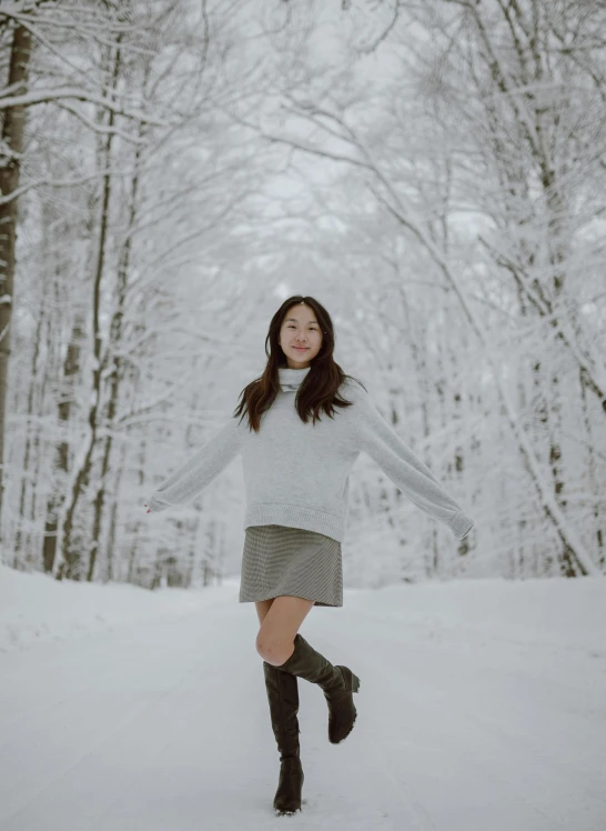 a woman standing in the snow with her arms outstretched, inspired by Kim Tschang Yeul, pexels contest winner, realism, white miniskirt, wearing casual sweater, enjoying a stroll in the forest, avatar image