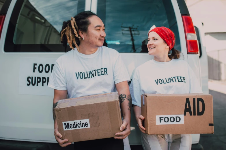 a couple of people holding boxes in front of a van, by Julia Pishtar, pexels contest winner, hunger, health supporter, te pae, ngai victo and dougherty patrick