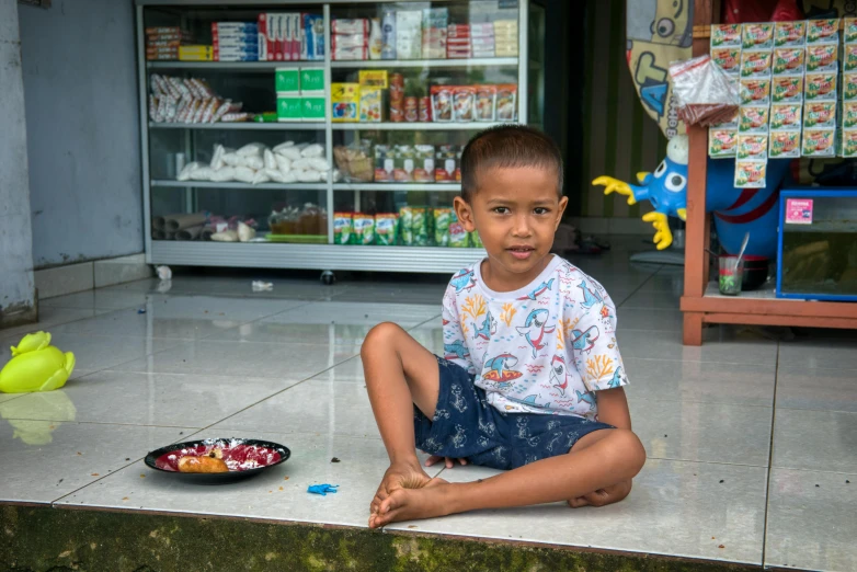 a young boy sitting on the ground in front of a store, pexels contest winner, sumatraism, avatar image, ready to eat, square, thumbnail