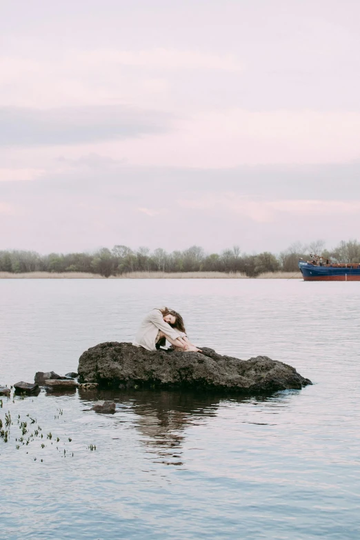 a dog is sitting on a rock in the water, an album cover, inspired by Anka Zhuravleva, pexels contest winner, romanticism, ship on lake, spring evening, wedding photo, model posing